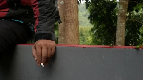 A man's hand holding a lit cigarette Stock Footage 165849595