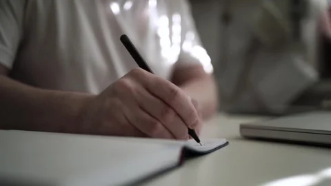 Mans Hand Holding a Pen While Writing on a Notebook. Journaling his thought.. Video stock 306064456