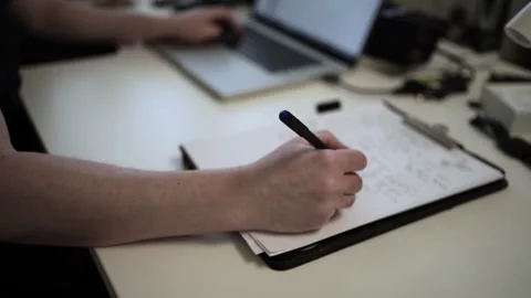 Mans Hand Holding a Pen While Writing on a Notebook. Journaling his thought.. Stock Footage 306064548