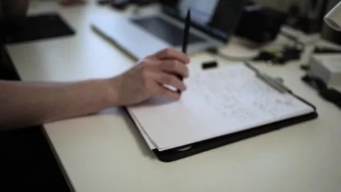 Mans Hand Holding a Pen While Writing on a Notebook. Journaling his thought.. Stock-Footage 306064659