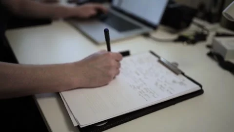 Mans Hand Holding a Pen While Writing on a Notebook. Journaling his thought.. Видео 306065794