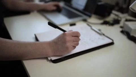 Mans Hand Holding a Pen While Writing on a Notebook. Journaling his thought.. Stock Footage 306067805