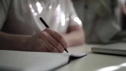Mans Hand Holding a Pen While Writing on a Notebook. Journaling his thought.. Stock Footage 306068964