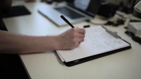Mans Hand Holding a Pen While Writing on a Notebook. Journaling his thought.. Stock Footage 306069052