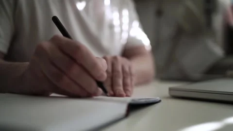 Mans Hand Holding a Pen While Writing on a Notebook. Journaling his thought.. Stock Footage 306069149