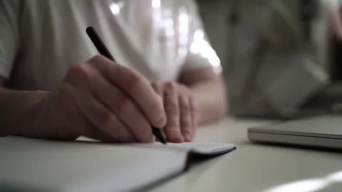 Mans Hand Holding a Pen While Writing on a Notebook. Journaling his thought.. Stock Footage 306069290