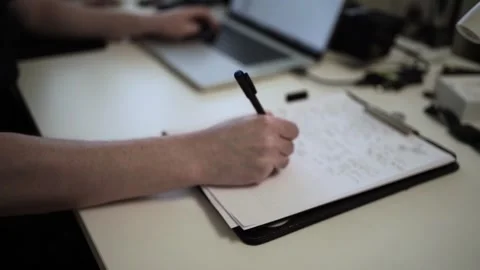 Mans Hand Holding a Pen While Writing on a Notebook. Journaling his thought.. Видео 306069399