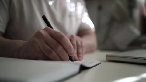 Mans Hand Holding a Pen While Writing on a Notebook. Journaling his thought.. Video stock 306069959