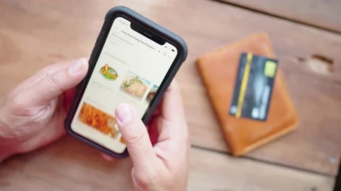 Man's hand holding a smart phone to find credit card payment information. Stock Footage 148101416