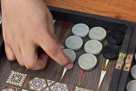 A man's hand holds a backgammon game Foto stock