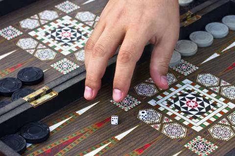 A man's hand holds a backgammon game Foto stock