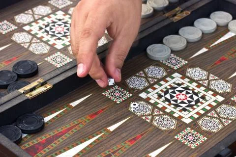 A man's hand holds a backgammon game Foto stock