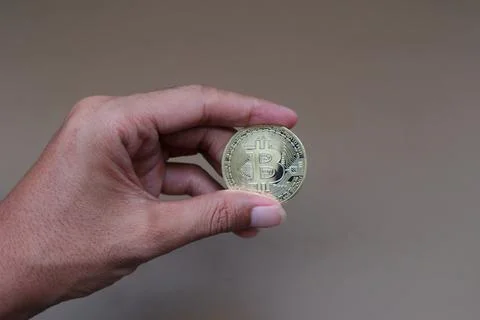 A man's hand holds bitcoin Stock Photos
