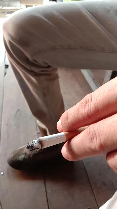 A man's hand holds a cigarette with two index and middle fingers Stock Footage 285947600