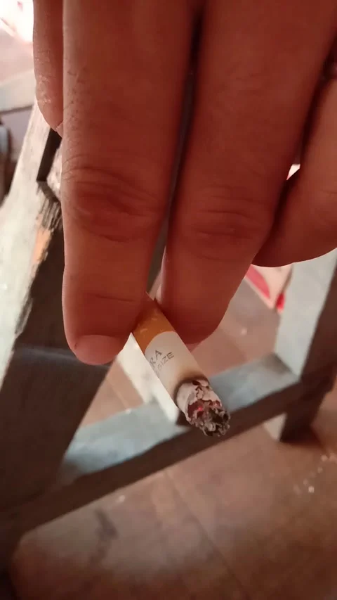 A man's hand holds a cigarette with two index and middle fingers Stock Footage 285947605