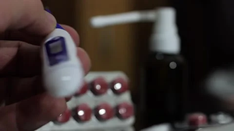 A man's hand holds a digital thermometer Stock Footage 258796226