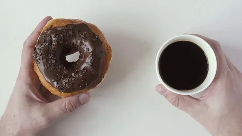 Man's hand holds a donut and coffee soluble. Top view Stock Footage 73928792