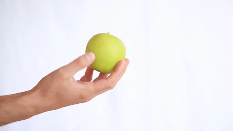 Man's hand holds fruit on a white background. green apple Stock Footage 75807170