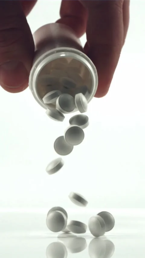 The man's hand holds a jar of falling pills. Filmed is slow motion 1000 fps Stock Footage 335285874
