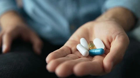 Man's hand holds multi-colored pills, tablets, dietary supplements Stock Footage 129184604