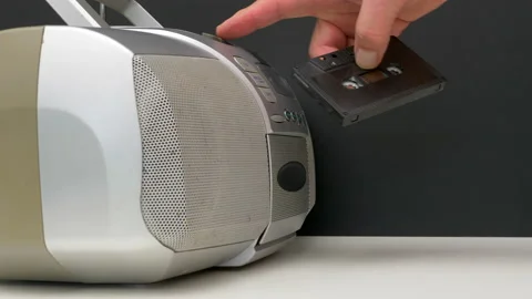 Man’s hand inserting an audio cassette into a portable player. Stock Footage 138868200