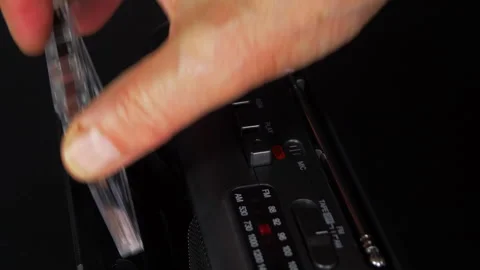 Man’s hand inserting an audio cassette tape into a portable player. Stock-Footage 247641804