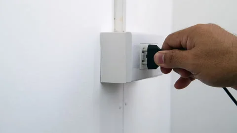 Man's hand inserting an electrical plug into a wall socket. Stock-Footage 171668328