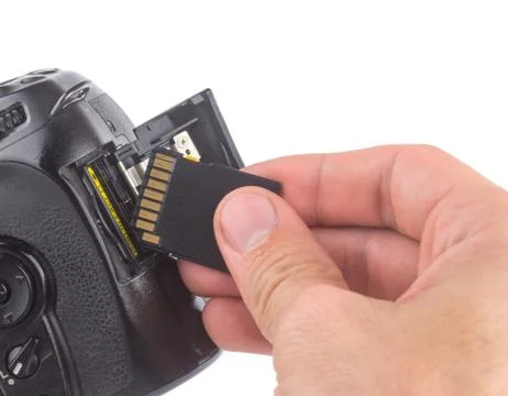 Mans hand inserts  a memory card into a camera  isolated on a white backgroun Stock Photos