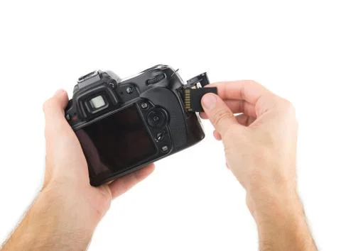 Mans hand inserts  a memory card into a camera  isolated on a white backgroun Stock Photos