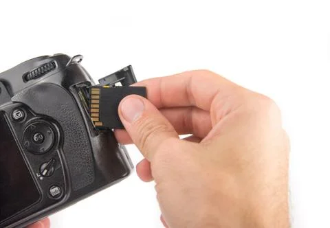 Mans hand inserts  a memory card into a camera  isolated on a white backgroun Stock Photos