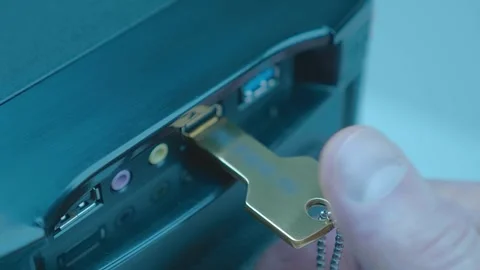 A man’s hand inserts (remove) a computer flash drive in the form of a golden key Stock Footage 259688951