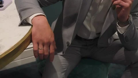 A mans hand in a jacket on the edge of a table 库存影片 329093632