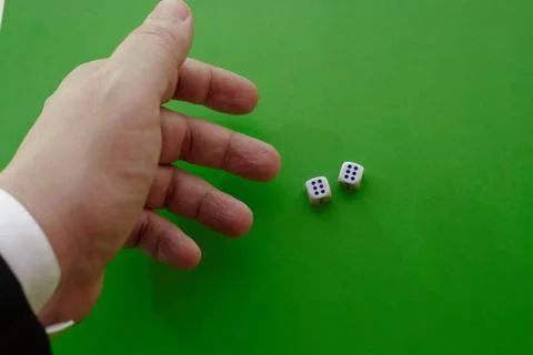 A mans hand in a jacket throws two dice on a green cloth, two winning dice, t Stock Photos