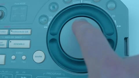 A man's hand on Jog Shuttle video editing console, collects a clip and push mark Stock Footage 259724775