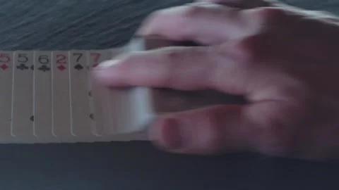 A man's hand lays out a deck of playing cards in a line Stock Footage 197387829