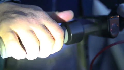 A man's hand in the light of lanterns holds the handle of an individual two-whee Stock Footage 131512557