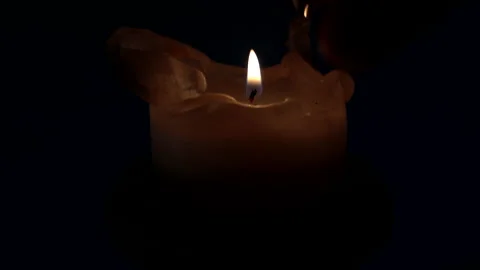 Man's hand lights a candle in the night dark. Stock Footage 237153953