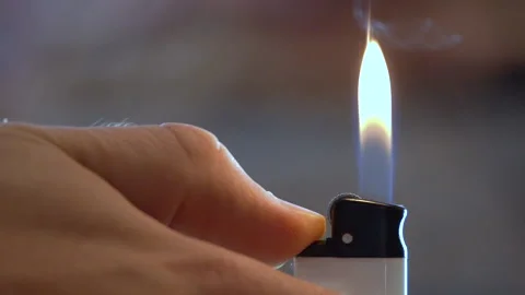 A man's hand lights a lighter, slow motion Stock Footage 165157432