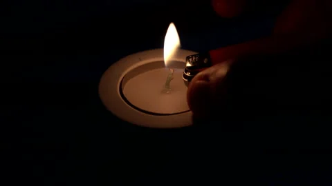 Man's hand lights a small candle in the night dark. Stock Footage 237154204
