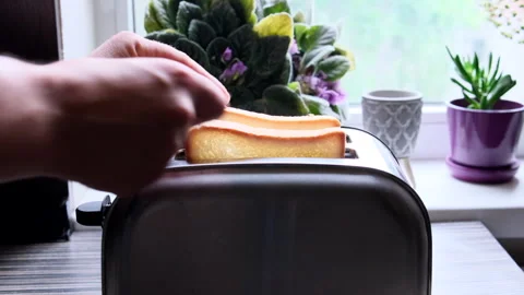 A man's hand loads two pieces of white bread into 動画素材 243837891