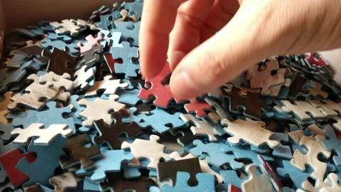 Man's hand looking for the perfect jigsaw puzzle piece. Stock Footage 227336482