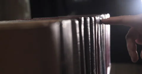 A mans hand is looking for the right book among a collection of volumes Stock Footage 166236941