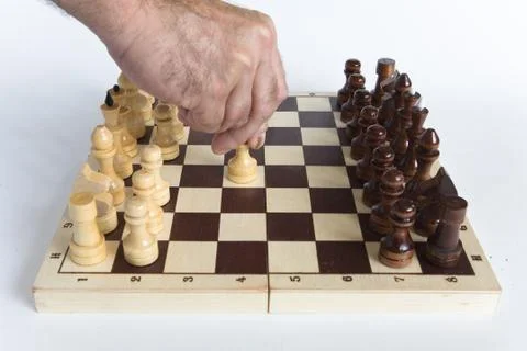 The man's hand makes the first move E2-E4. Stock Photos