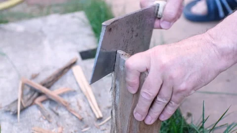 Man's hand makes wood chips for a bonfire with an axe blade Video stock 244737136