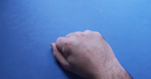 A man's hand with many different pills on a blue background Stock Footage 130776149