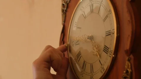 Man's hand moves clock arrow forward - time adjustment and correction Stock Footage 70816304