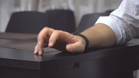Mans hand is nervously tapping his fingers on the table Stock Footage 150386142