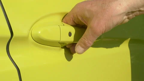 Man's hand opening the driver's door of a bright yellow car. Video stock 158573153