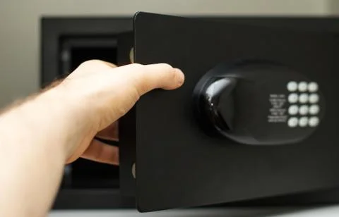 Man's hand opening small safe. Stock Photos