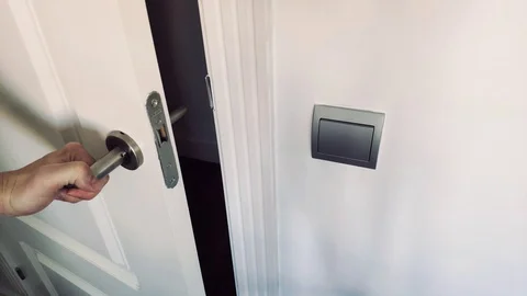 Man's hand opening white door with switch next to it. Stock Footage 128113082